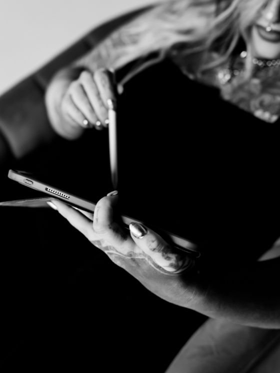 A group of diverse young professionals collaborating in an office setting, smiling and looking at a tablet device together